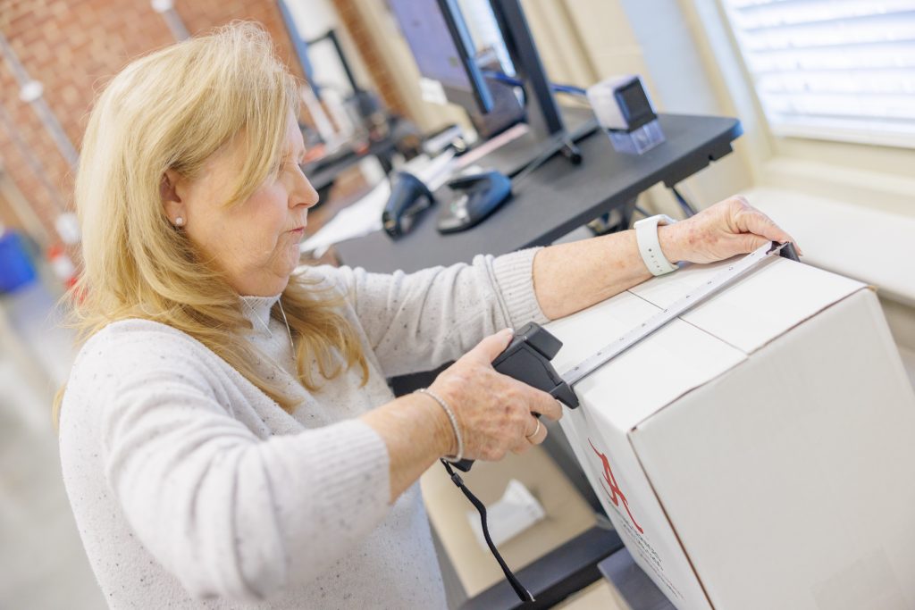 Campus Mail worker measuring a box