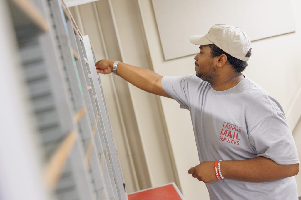Campus Mail worker putting mail into boxes