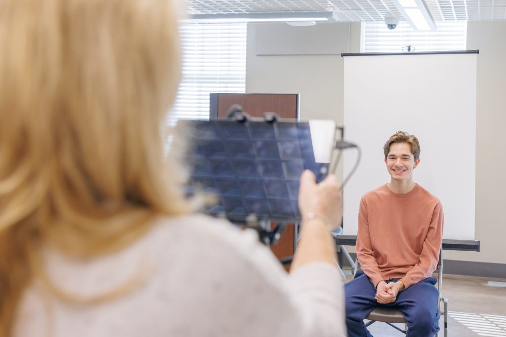 Passport Agent taking a passport picture of a customer.