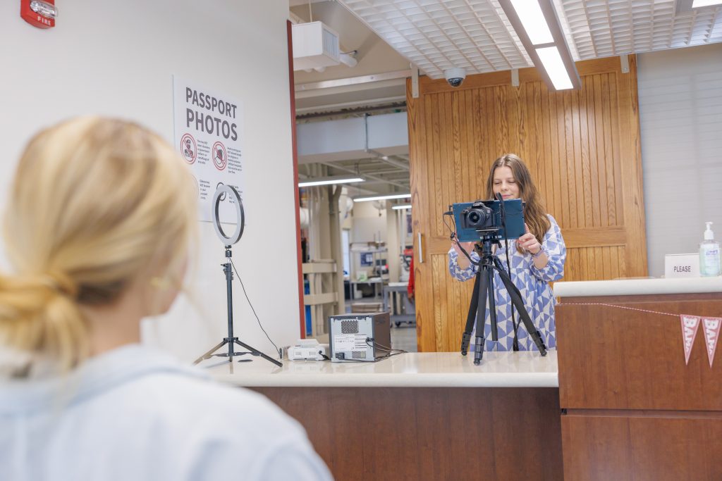 Passport Agent taking a passport picture of a customer